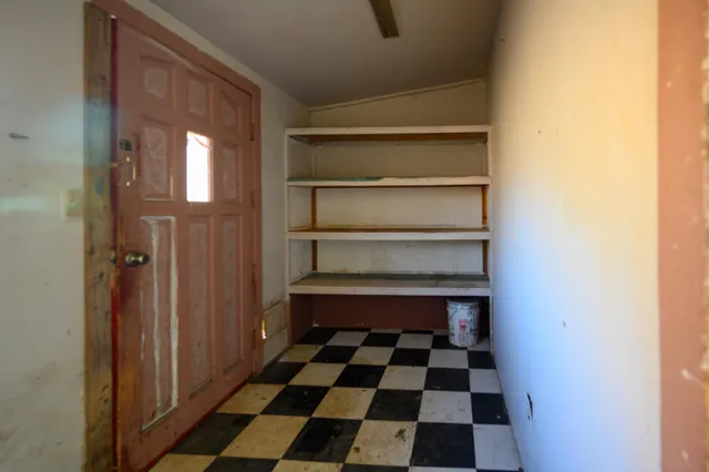 a room with a black white checkered floor and a window