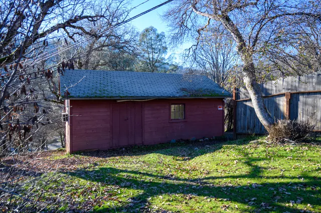 a view of backyard of house with wooden fence