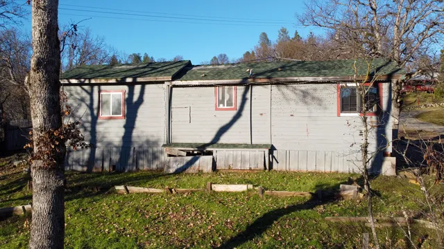 a view of a house with backyard and sitting area