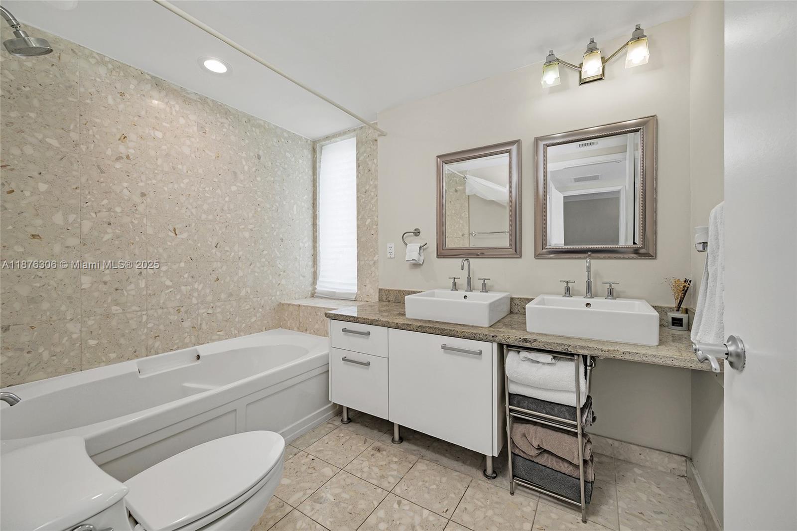 185 Southwest 7th Street, Unit 4201 Miami, FL 33130 - Photo 18 of 29 a bathroom with a toilet a sink a mirror and a bathtub