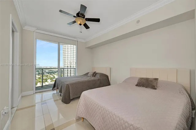 a bedroom with two beds and a large window