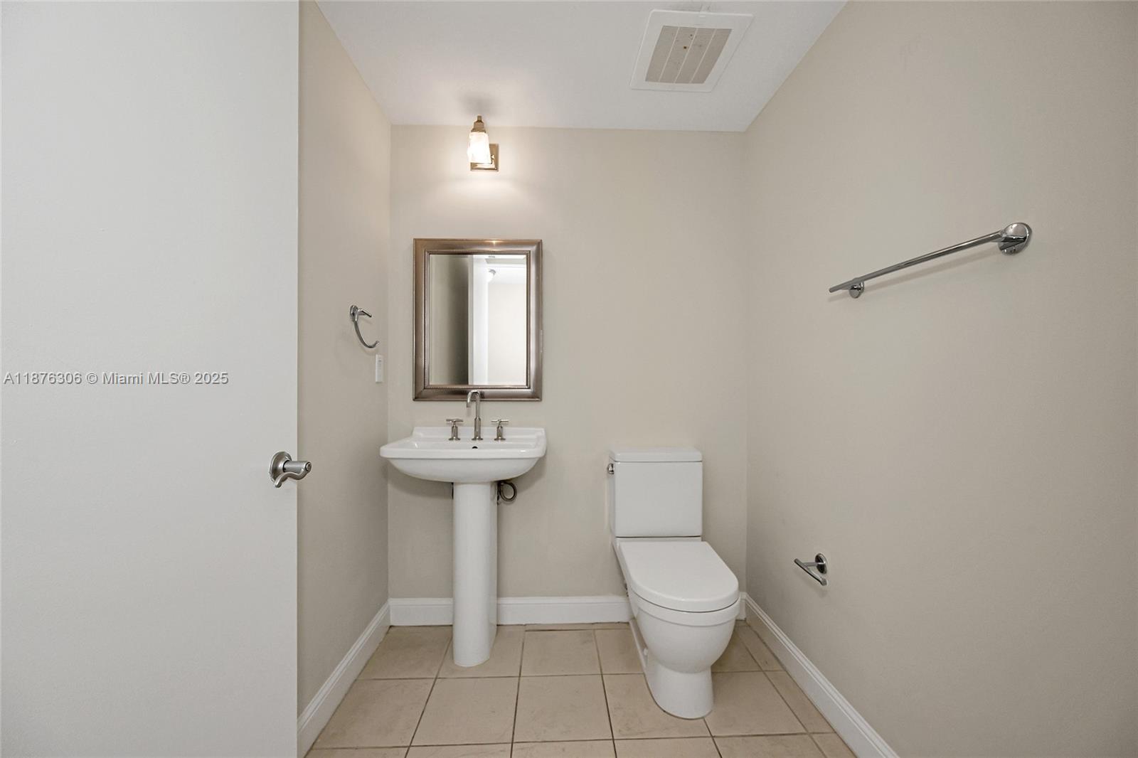 185 Southwest 7th Street, Unit 4201 Miami, FL 33130 - Photo 25 of 29 a bathroom with a toilet a sink and mirror