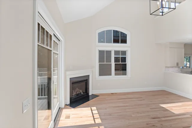 a living room with a fireplace furniture a rug and a window