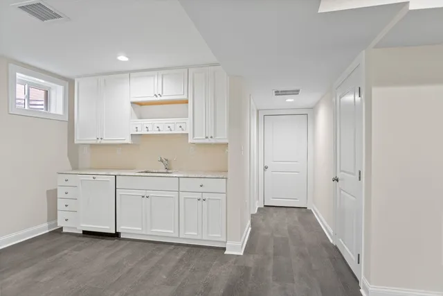 a view of a kitchen with white cabinets
