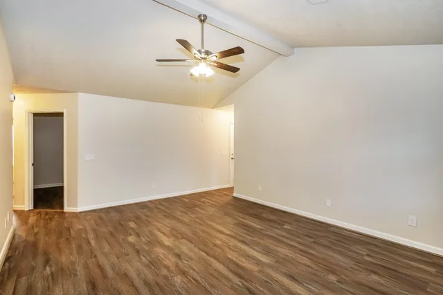 a view of an empty room with wooden floor