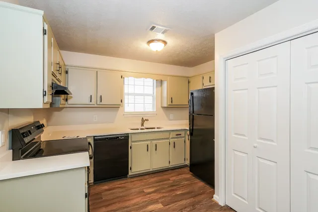 a kitchen with a sink a refrigerator and cabinets