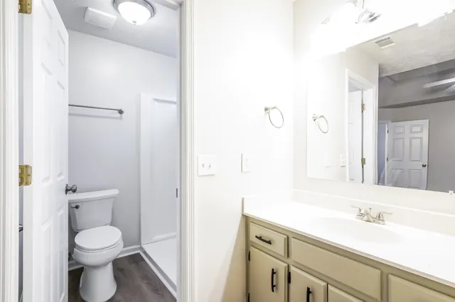 a bathroom with a toilet a sink and mirror