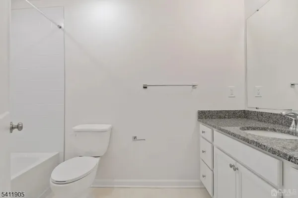 a bathroom with a granite countertop toilet and a sink