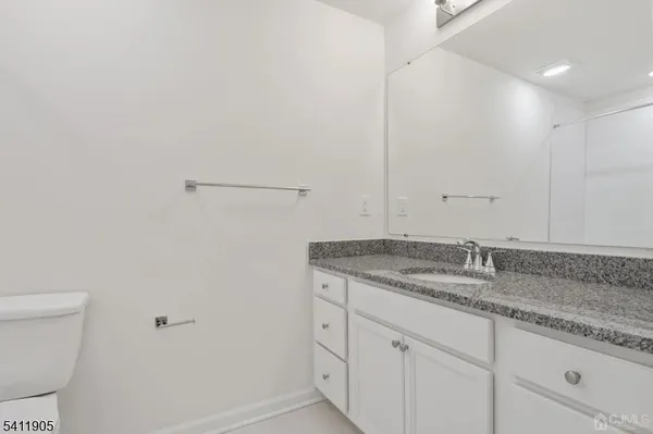 a bathroom with a granite countertop sink and toilet
