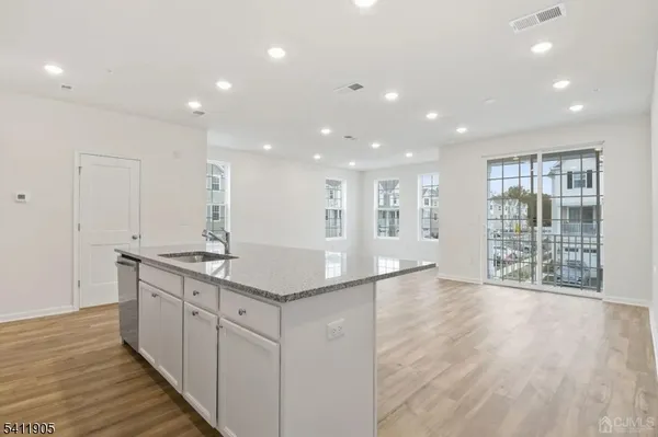 a kitchen with stainless steel appliances granite countertop a stove and a wooden floors