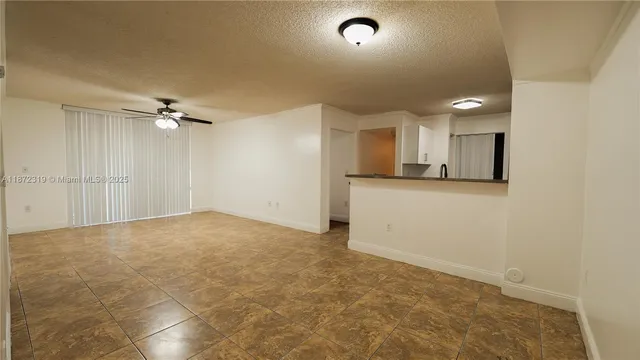 a view of a hallway with wooden floor and a bathroom