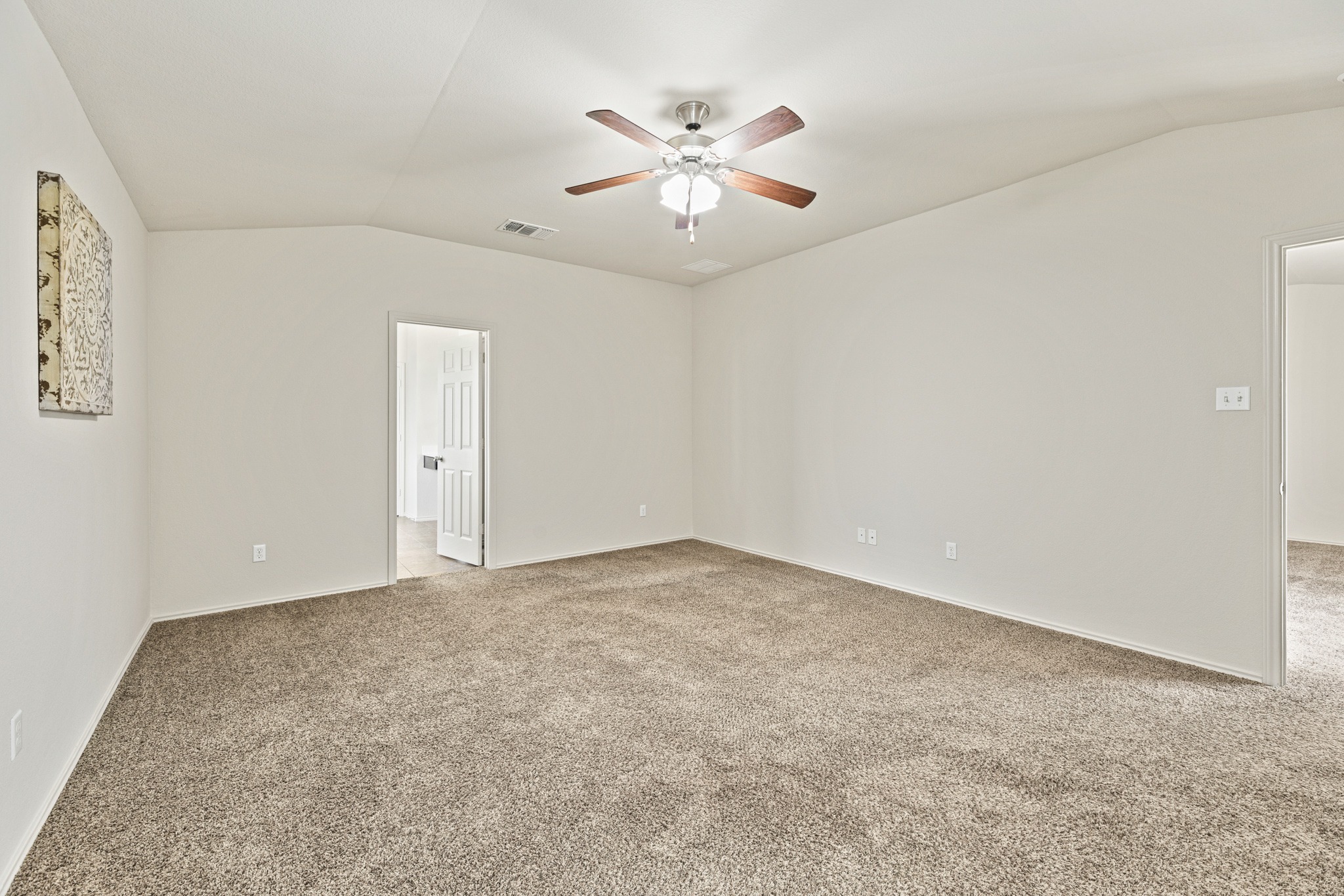 232 Geode Lane Jarrell, TX 76537 - Photo 19 of 39 Primary bedroom plush carpeting and vaulted ceilings define this versatile open room.