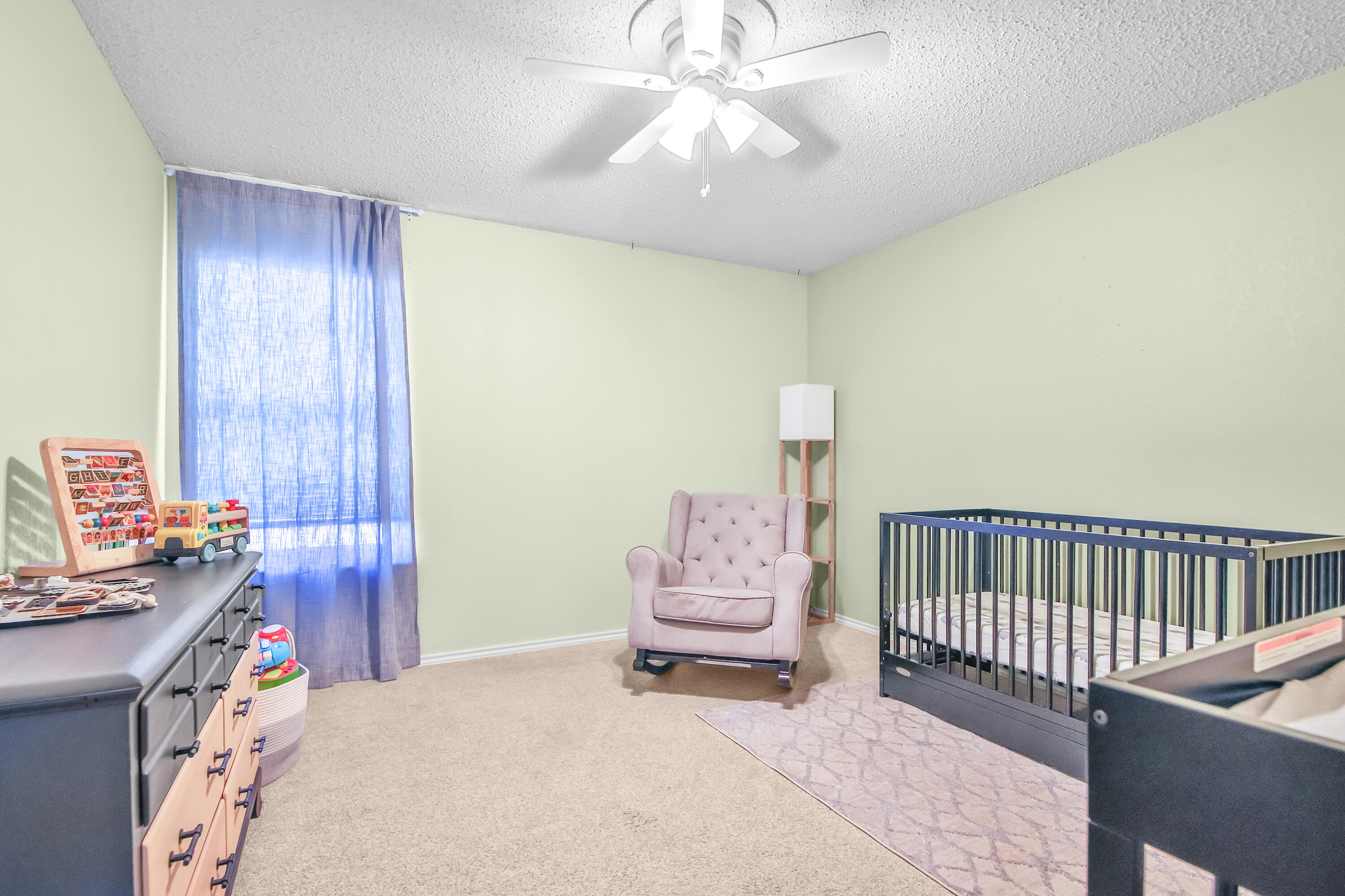 4805 73rd Street Lubbock, TX 79424 - Photo 21 of 26 a bedroom with a bed and a chandelier