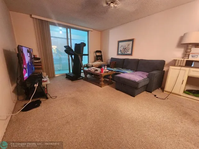 a living room with furniture a window and gym equipment