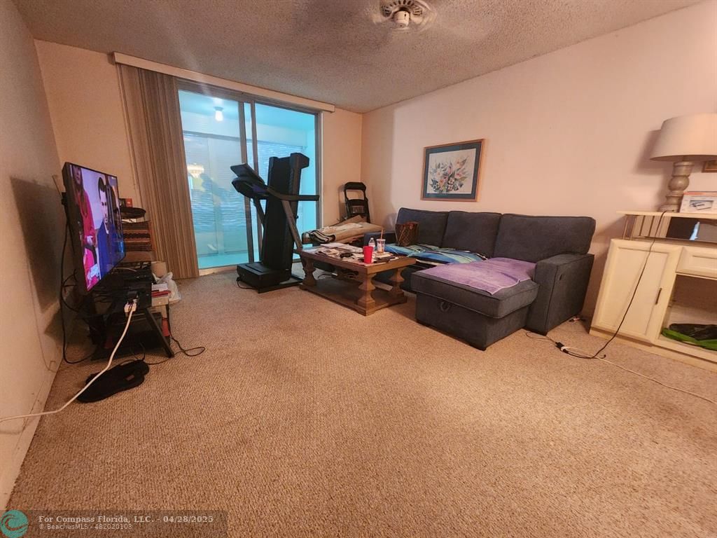 a living room with furniture a window and gym equipment