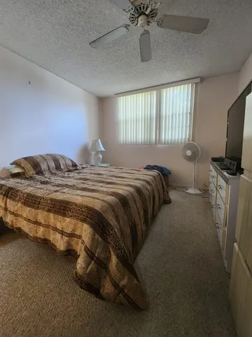 a bedroom with a bed and a flat tv screen on the dresser