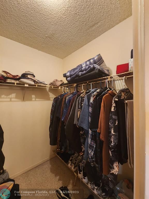 5851 Northwest 62nd Avenue, Unit 105 Tamarac, FL 33319 - Photo 7 of 18 a view of walk in closet with clothes and shoes
