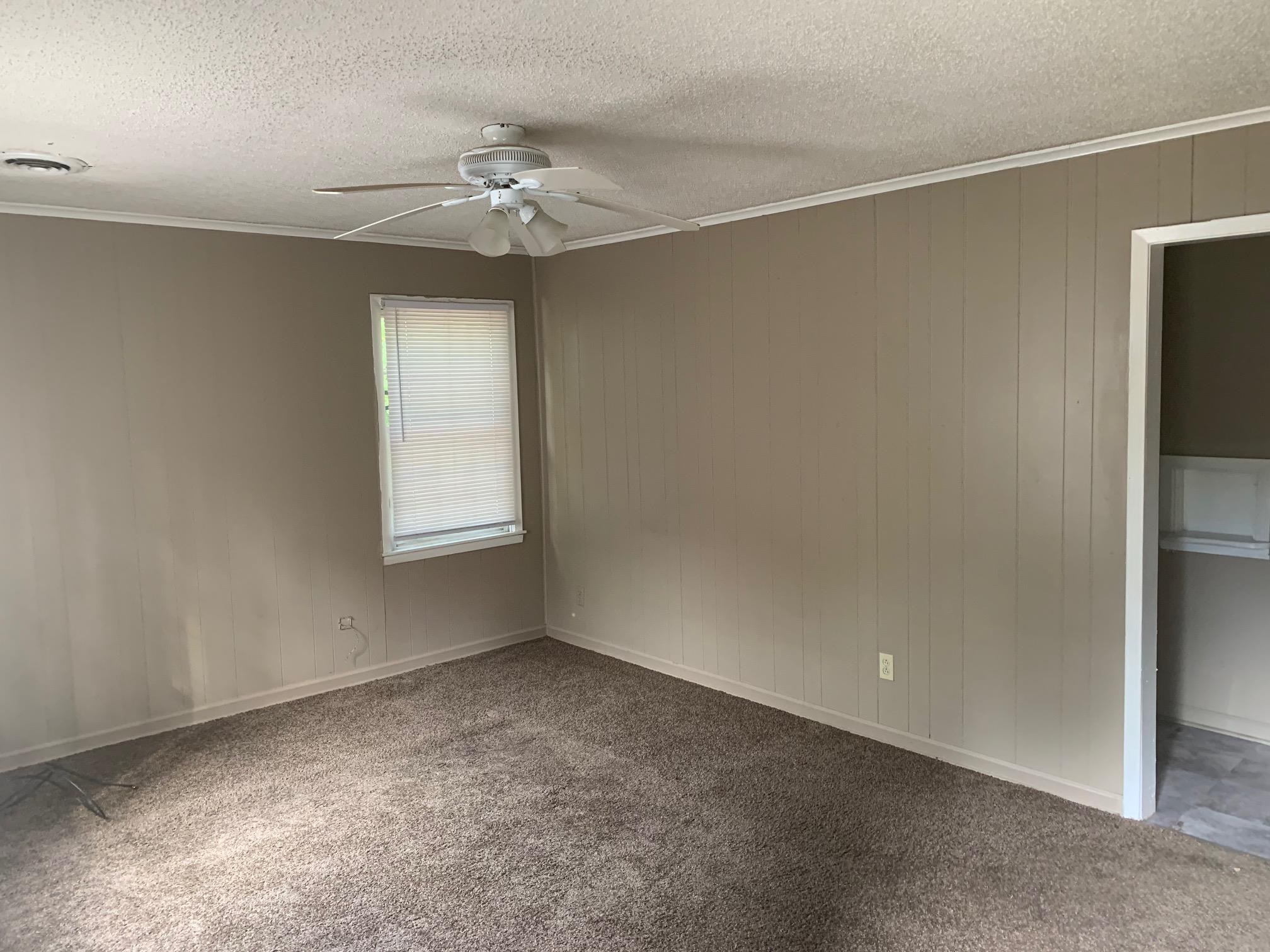 3054 Coleman Avenue Memphis, TN 38112 - Photo 2 of 11 an empty room with a chandelier fan and windows