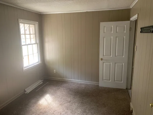 an empty room with windows and closet
