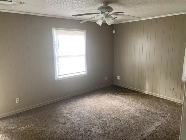 an empty room with a window and a fan
