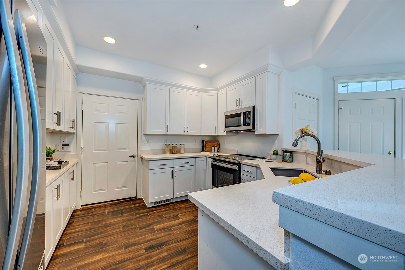 555 Anacortes Court Northeast, Unit 101 Renton, WA 98059 - Photo 8 of 22 a kitchen with stainless steel appliances granite countertop a refrigerator and a stove top oven