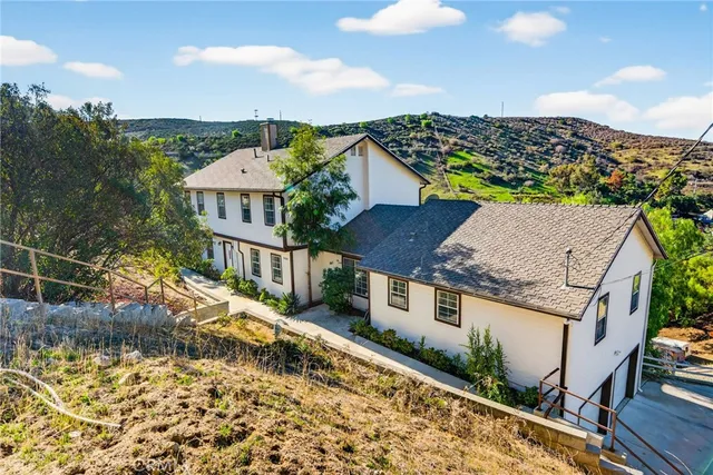 a view of a house with a yard and potted plants