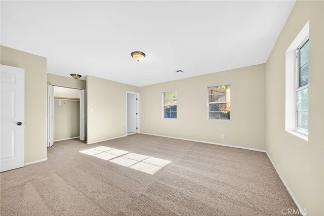 an empty room with windows and closet