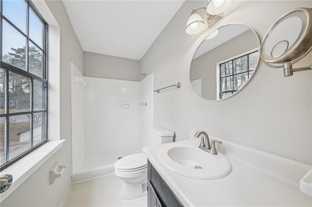 337 Independence Drive Jonesboro, GA 30238 - Photo 20 of 41 a bathroom with a toilet a sink and a mirror