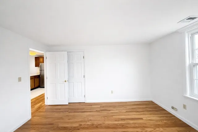 a view of a livingroom with wooden floor and a window