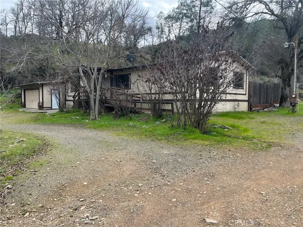 a view of a house with a yard and tree