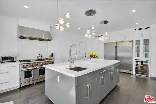 a kitchen with a sink and a stove top oven with wooden floor