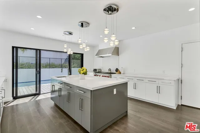 a kitchen with a sink stove and wooden floor