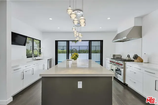 a kitchen with white cabinets and chandelier