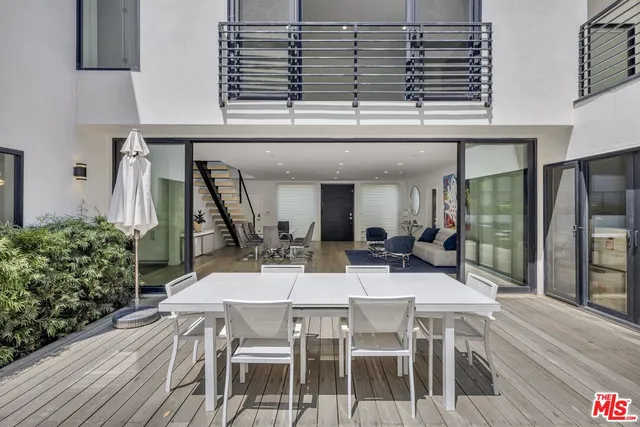 a view of a patio with table and chairs potted plants with wooden floor
