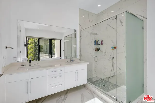 a bathroom with a shower sink and mirror