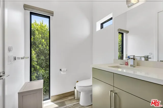 a bathroom with a granite countertop sink toilet and a mirror