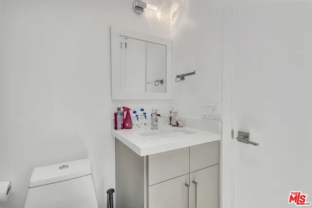 a bathroom with a sink vanity and toilet