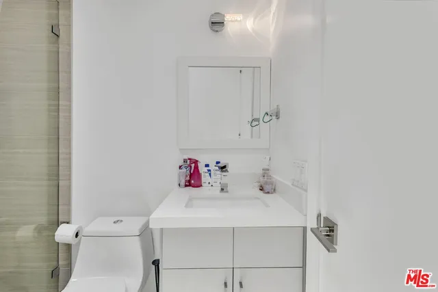 a bathroom with a sink a toilet and shower