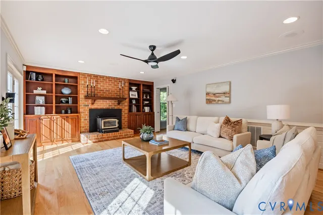 an empty room with wooden floor ceiling fan and windows