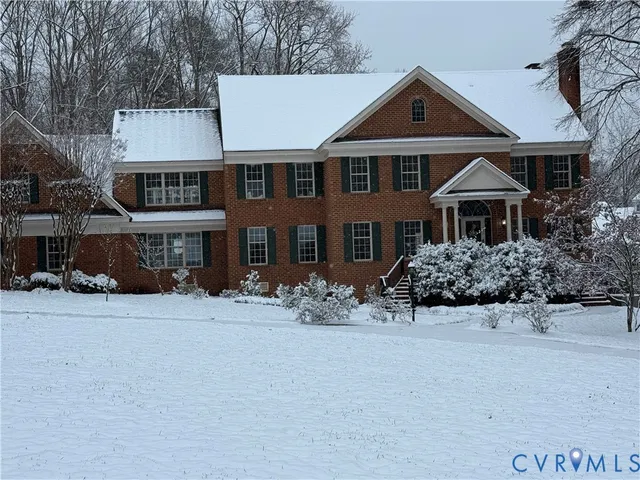 a front view of a house with a yard and trees