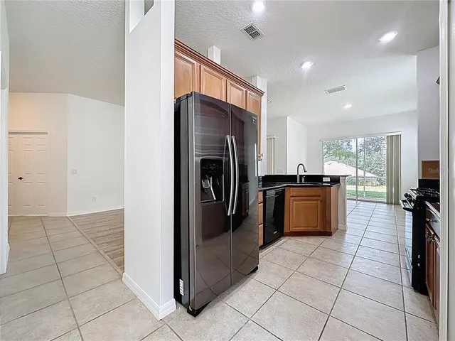 a kitchen with stainless steel appliances granite countertop a stove a sink and a refrigerator
