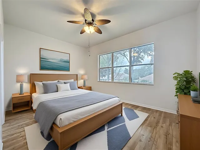an empty room with wooden floor closet and windows
