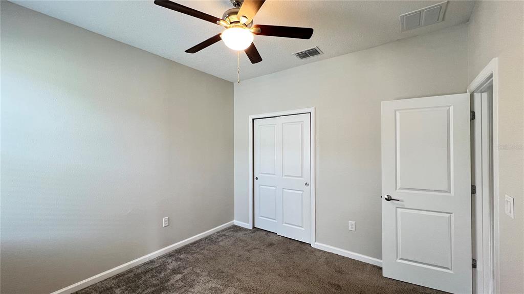 16466 Glassy Loch Loop Clermont, FL 34714 - Photo 13 of 37 an empty room with closet and a chandelier fan