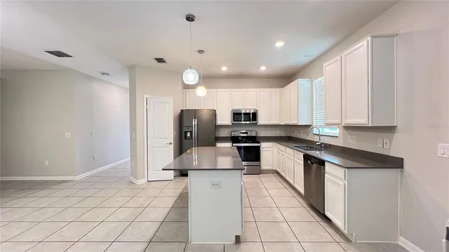 a large kitchen with stainless steel appliances lots of counter space and a sink