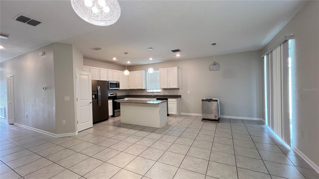 16466 Glassy Loch Loop Clermont, FL 34714 - Photo 22 of 37 a kitchen with stainless steel appliances kitchen island granite countertop a refrigerator and a sink