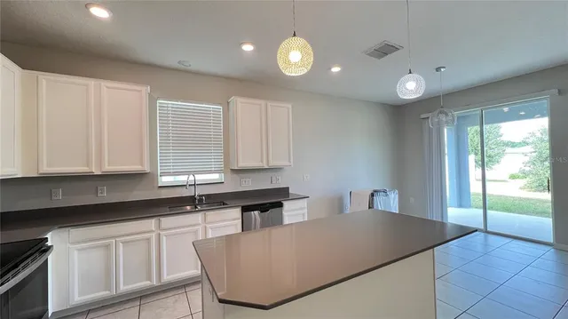 a kitchen with granite countertop a sink and white cabinets