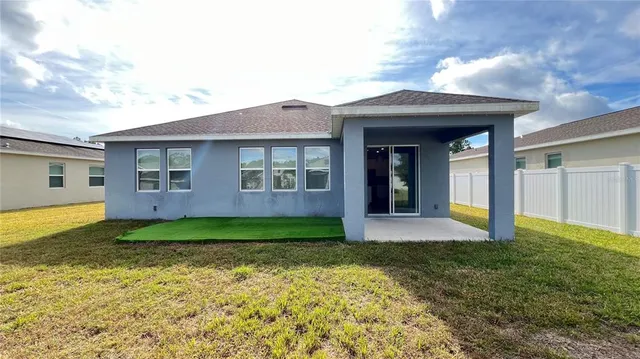 a view of a yard in front of a house with a large tree