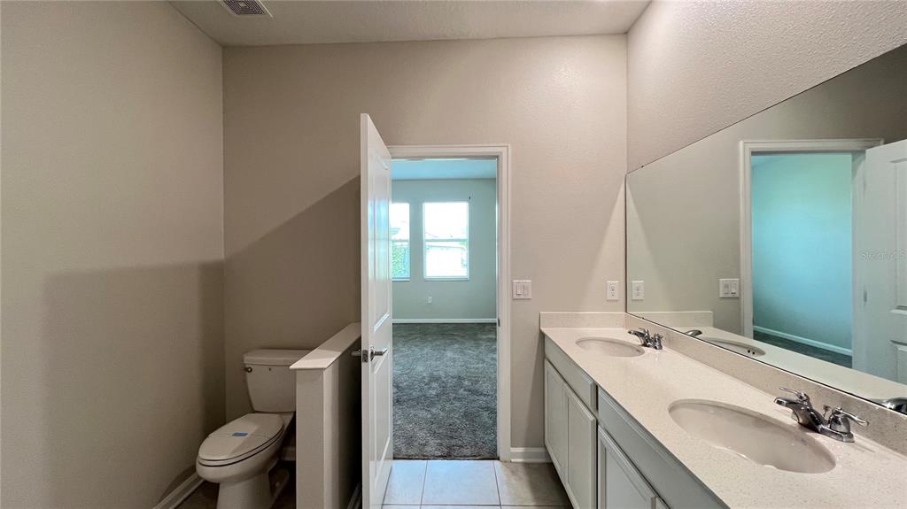 16466 Glassy Loch Loop Clermont, FL 34714 - Photo 36 of 37 a spacious bathroom with a granite countertop sink a toilet and a mirror
