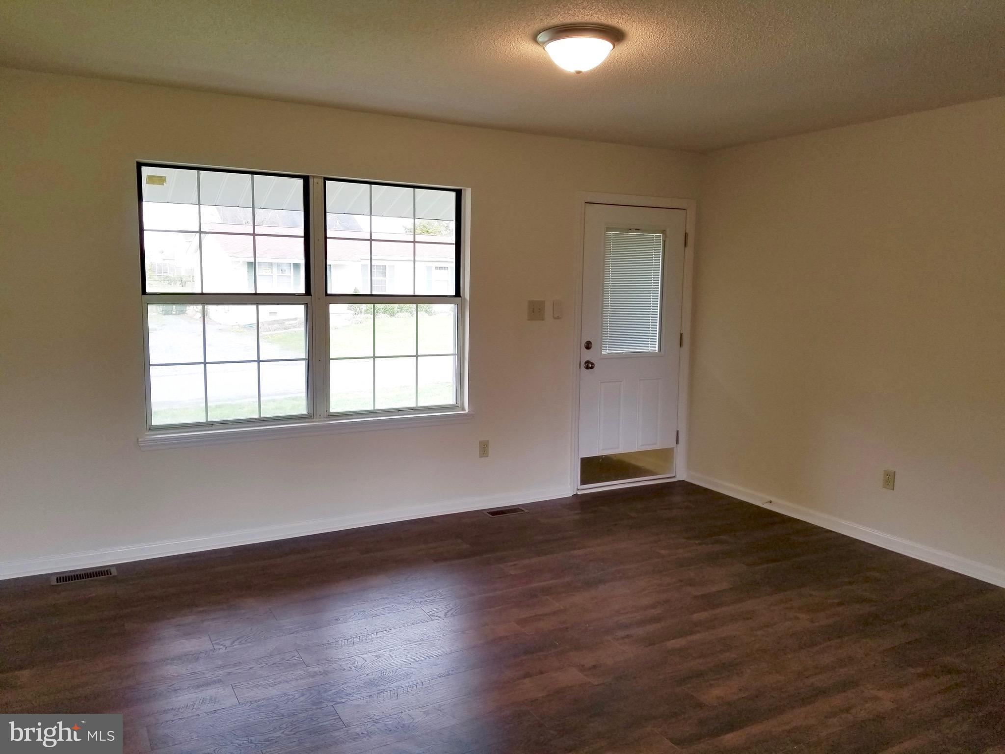 135 Truman Road Inwood, WV 25428 - Photo 3 of 30 an empty room with wooden floor and windows