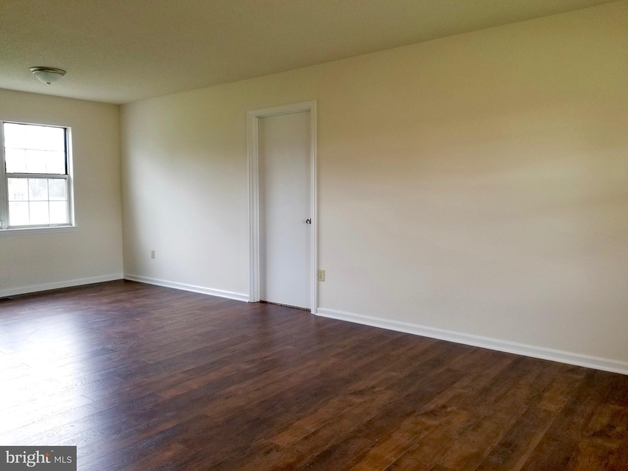 135 Truman Road Inwood, WV 25428 - Photo 5 of 30 an empty room with wooden floor and windows